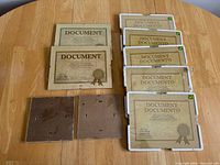 All ten pieces laid out on table: six sealed frames, two open frames, two back panels