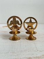 Front view showing both brass candle holders with angel and star designs