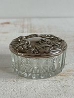Closed jar showing cut glass base and silver-plated floral lid