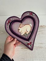 Front view of heart-shaped metal plaque with bunny painting