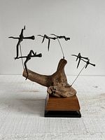 Full view of sculpture showing birds, driftwood, and base
