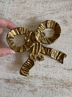 Front view of brass bow hook showing shape and finish