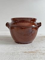 Front view of brown glazed Pearson stoneware pot showing bead detail and handles