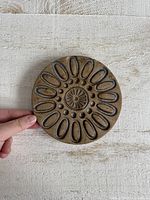 front view showing full floral design of trivet