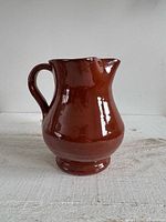 Front view of terracotta jug showing pinched spout and handle