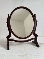 Front view of oval wood vanity mirror showing full structure