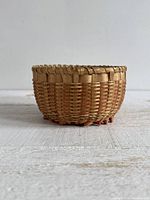 side view of round woven basket showing weave pattern and curled footing