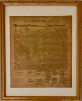 Front view of framed Declaration of Independence reproduction showing text, signatures, mat and gold wood frame.