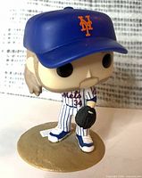Front view of Noah Syndergaard Funko Pop showing face, uniform, cap, glove, and base