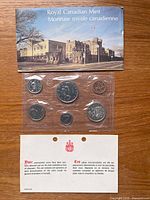 Front of sealed six-coin set with envelope and insert visible