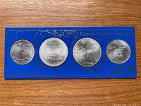 Full view of four coins mounted on blue display card