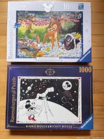 Fronts of both sealed puzzle boxes showing artwork and 1000-piece count