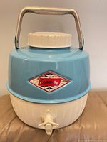 front view showing logo, spigot, blue top, white bottom