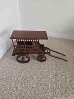 Full side view of wooden miniature wagon with roof and slatted sides