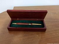 Pen inside open wooden box showing pen and interior