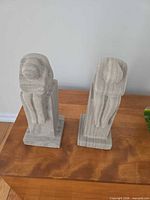 Front view of both gray cast stone abstract sculptures