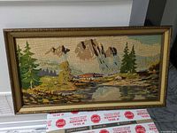 Front view of framed needlepoint landscape