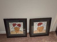 Both framed prints standing side by side on floor