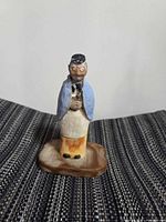 front view of carved wooden figurine on base