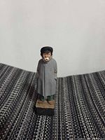 Front view of carved wood figurine showing full attire and facial details