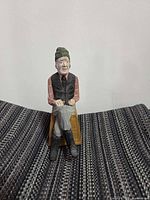 Front view of hand-painted wood carving on fabric surface