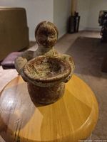 Front view of terracotta figurine showing bowl and overall shape