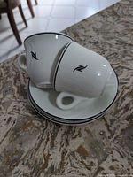 Two stacked espresso cups on saucers showing black rim and N logo