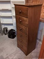 Front view of tall six-drawer dresser showing overall design and knobs