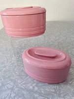 Both pink ceramic refrigerator dishes with lids displayed