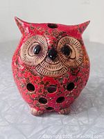 front view of glazed ceramic owl candle holder showing cutouts and eyes