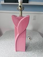 Front view of pink ceramic lamp showing flower motif and socket