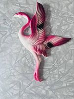 front view of pink and white ceramic flamingo wall figurine