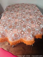 Full view of tablecloth on table showing pattern and fringe