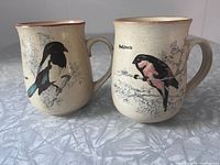 Front view of both mugs showing bird illustrations