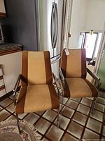 Two upholstered metal chairs showing overall design and upholstery pattern