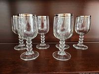 All six goblets showing silver rims and faceted stems