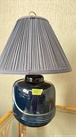 Full lamp showing ceramic base and pleated shade