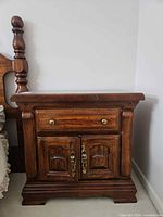 Front view of wooden nightstand showing drawer and doors closed