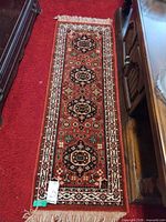 Full view of wool runner rug on red carpet