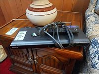 Top view of Sony DVP-NS707HP DVD player with cables and remote on unit