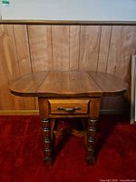 Front view showing table with both leaves raised, drawer front visible