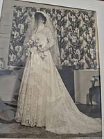 Full view of bride wearing the lace gown with veil and bouquet, showing train