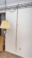 Full view of swag lamp hanging from ceiling showing long chain and cord
