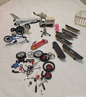 Group shot of all toys including shuttle, truck, helicopter, bikes, motorcycles, fingerboards, hardware