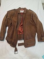 Front view of brown leather bomber jacket showing belt, zipper, snap cuffs, epaulettes