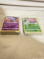 Two shrink-wrapped stacks of Pokémon cards, showing reverse holo Gastly and Vileplume on top