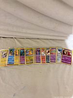 Spread of 13 sleeved holographic Pokémon cards showing variety and condition