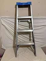 Full view of aluminum ladder, three steps, blue top
