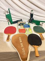 Lot overview: three paddles, case, net clamps, desktop kit, ball