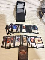 Full lot: black storage box filled with cards and additional stacks spread out plus single card showing back design